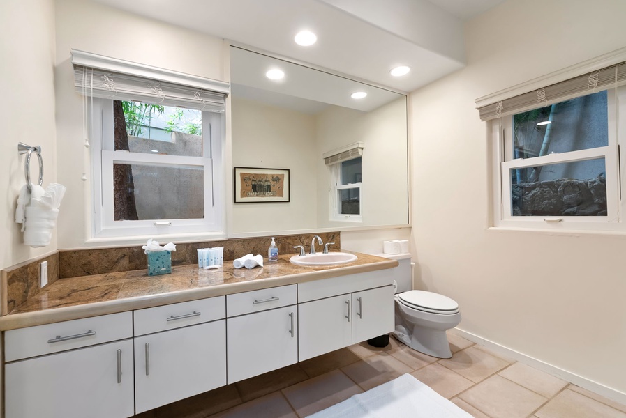 Your private bathroom features elegant granite countertops, modern fixtures, and thoughtful amenities including fluffy towels and toiletries.