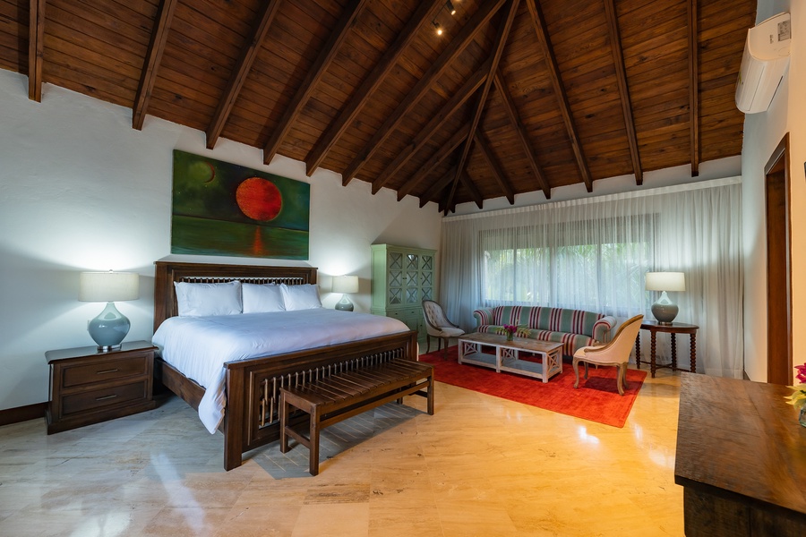 Retreat in the primary bedroom featuring a vaulted wooden ceiling and cozy seating area