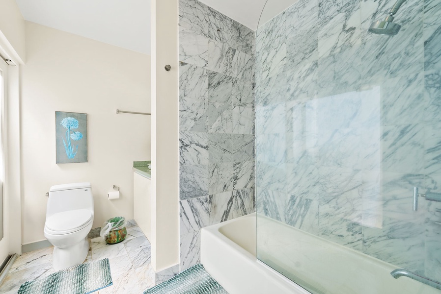 Luxurious bathroom with a marble-accented shower and tub, creating a spa-like experience.