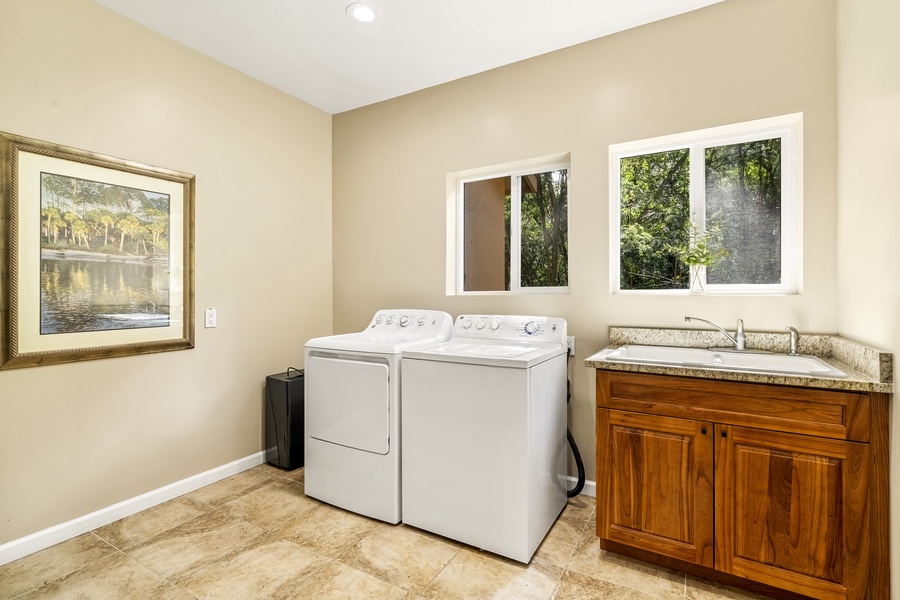 Full sized laundry room with washer, dryer and large sink
