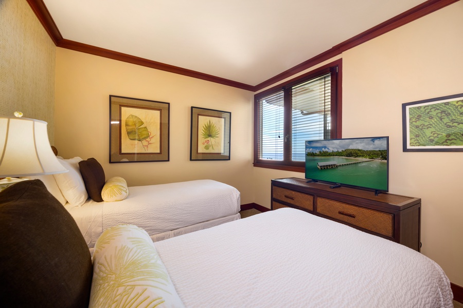 Relax in your comfortable twin bedroom with tropical artwork and flat-screen TV for cozy evenings after island adventures.