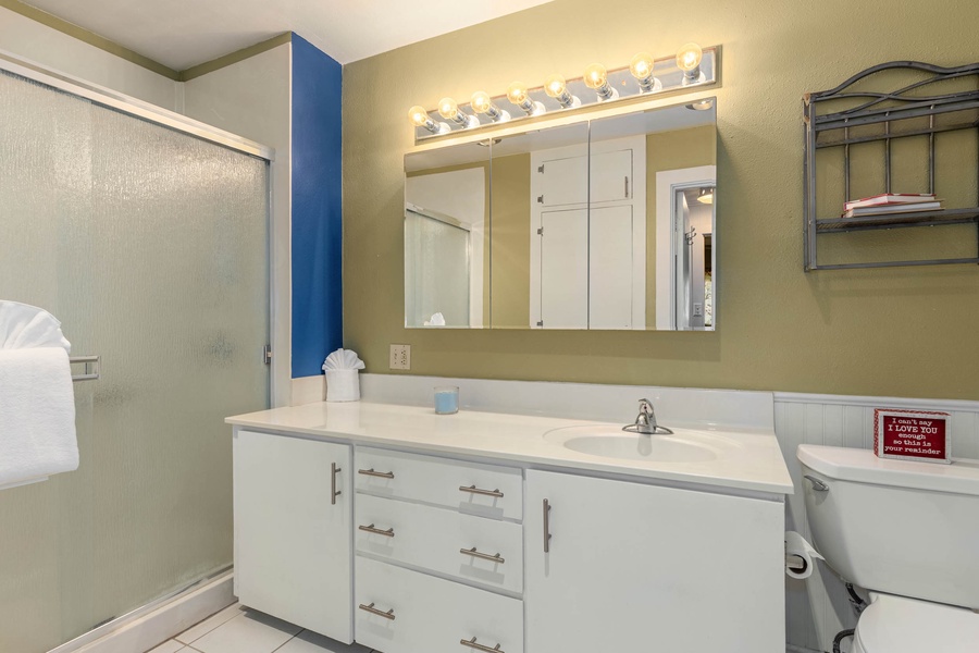 Common bathroom with a walk-in shower and a wide vanity space