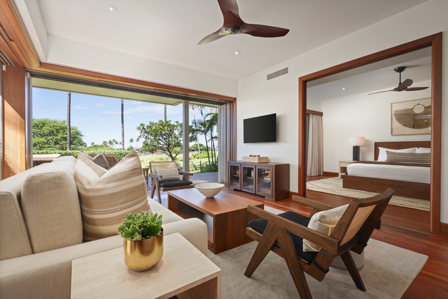 Alternate view of media room leading into primary bedroom with sliding pocket doors to separate spaces.