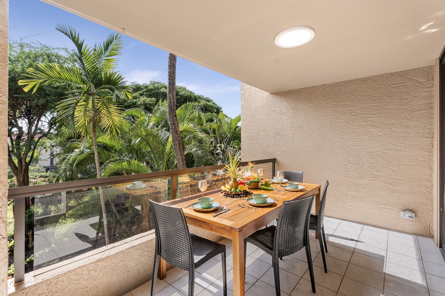 Balcony dining space surrounded by lush palms and peaceful vibes.