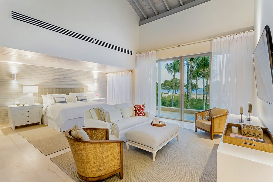 The primary bedroom upstairs features a king-sized bed, lounge area, vaulted ceilings and private balcony or deck.