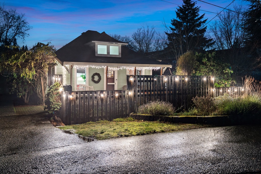 Nighttime view of the house adorned with warm holiday lights, inviting and cheerful.