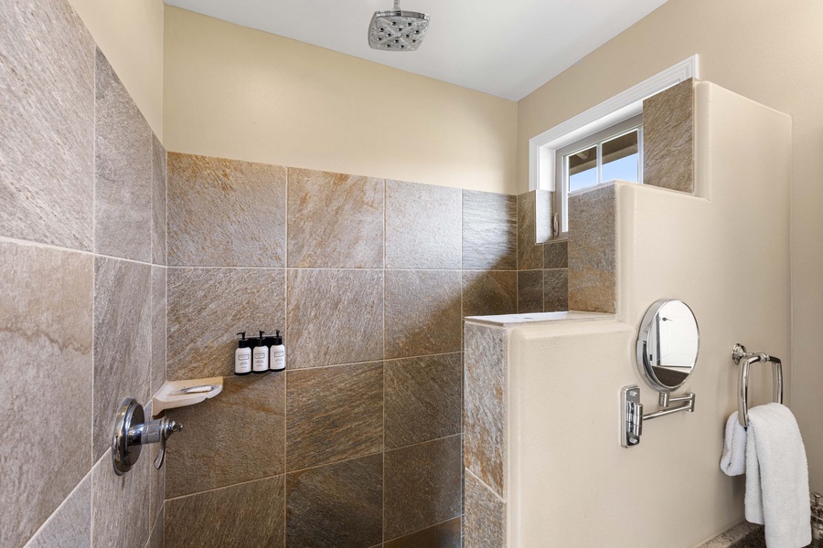 Rain style shower in the tiled walk in shower is perfect to relax after a day at the beach or at the pool