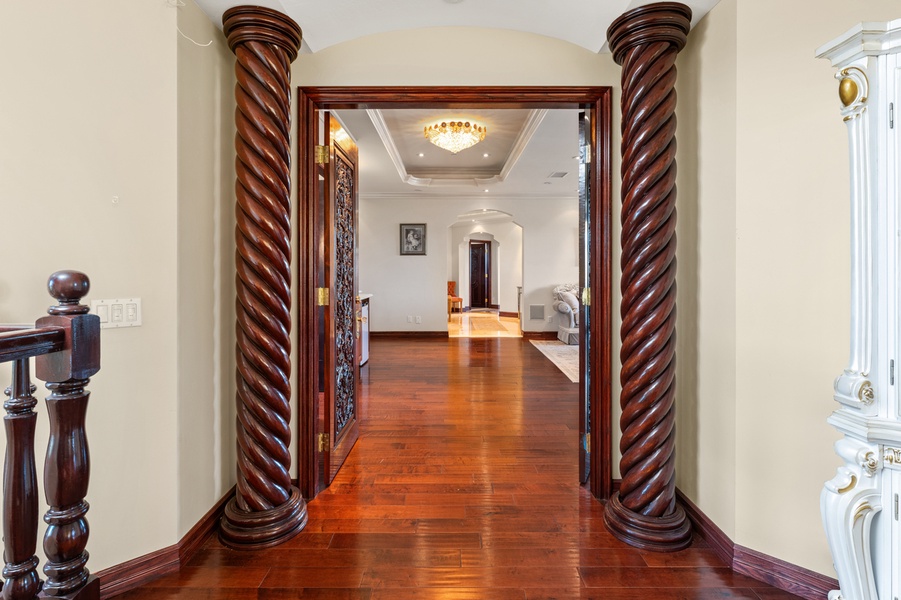 Carved wood pillars and luminous hardwood floors bring warmth and timeless elegance to every step.