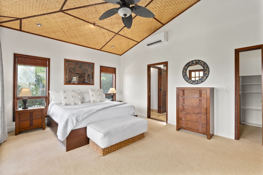 The primary suite in the upper-level features a king-sized bed, split AC, ceiling fan and views from the private deck.