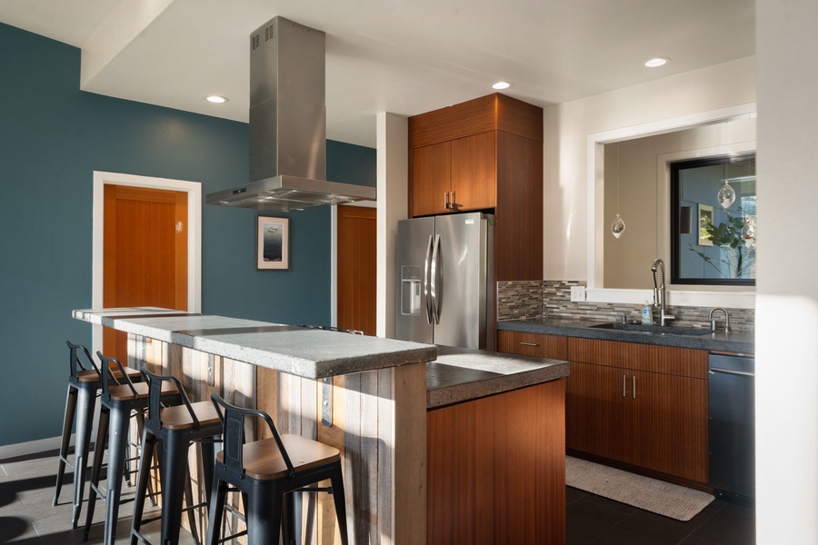 Your modern kitchen awaits with sleek appliances, warm wood finishes, and a breakfast bar where you can sip morning coffee.