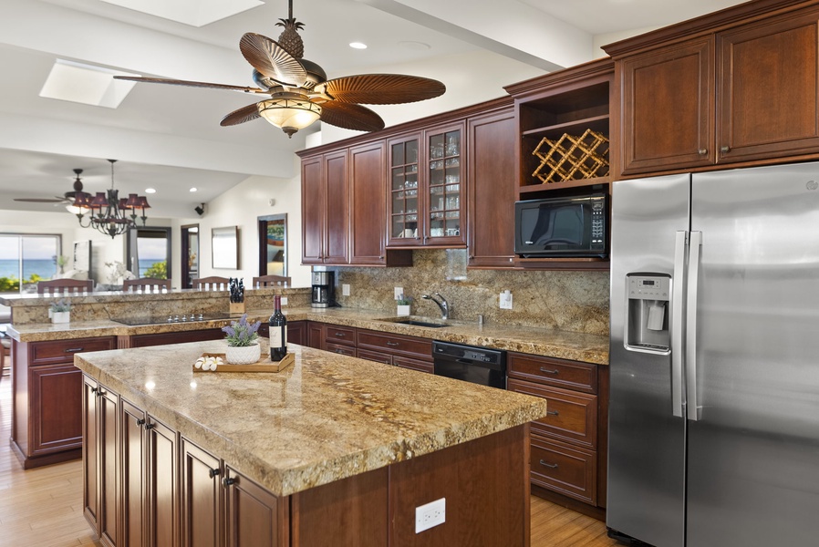 Granite countertops and dark wooden cabinets warmly welcome you into the home
