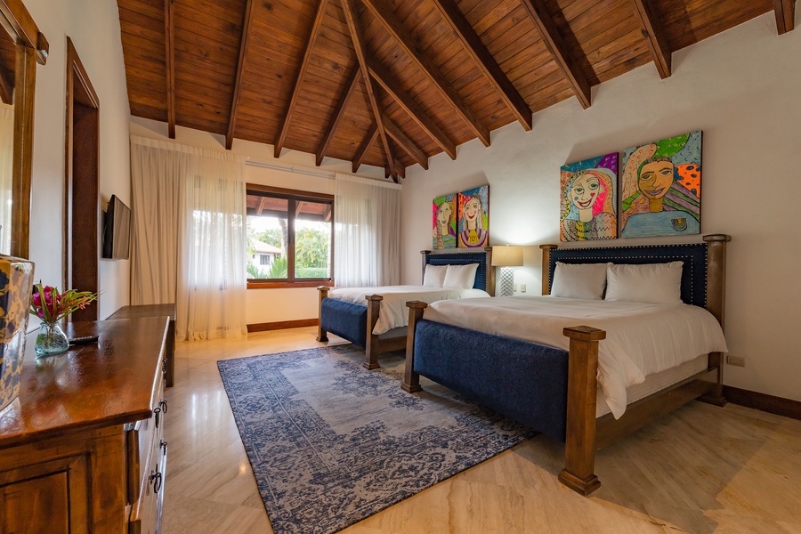 Guest bedroom featuring colorful artwork and garden views.
