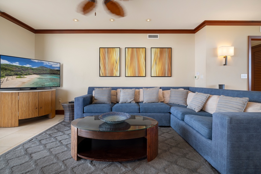 Unwind in this elegant living space with plush seating, beautiful art, and tropical views on the wall-mounted TV.