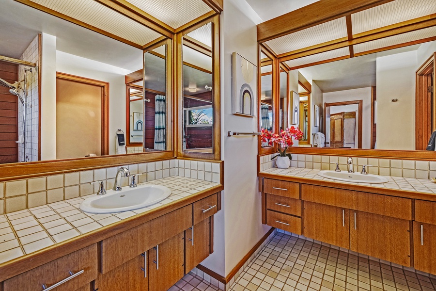 This stylish double vanity offers ample space for getting ready, complemented by warm wood tones and well-lit mirrors