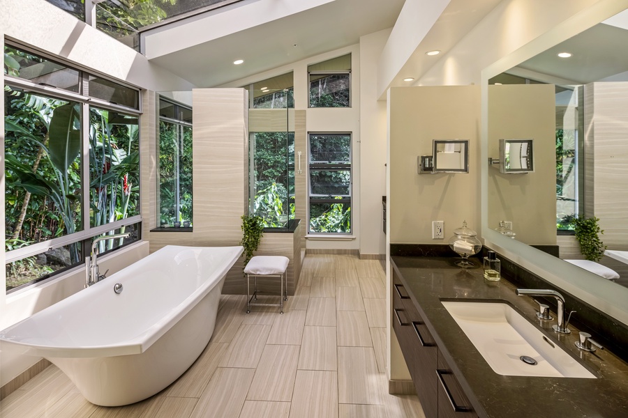 Spa-inspired ensuite bath with soaking tub, glass shower, and floor-to-ceiling forest views.