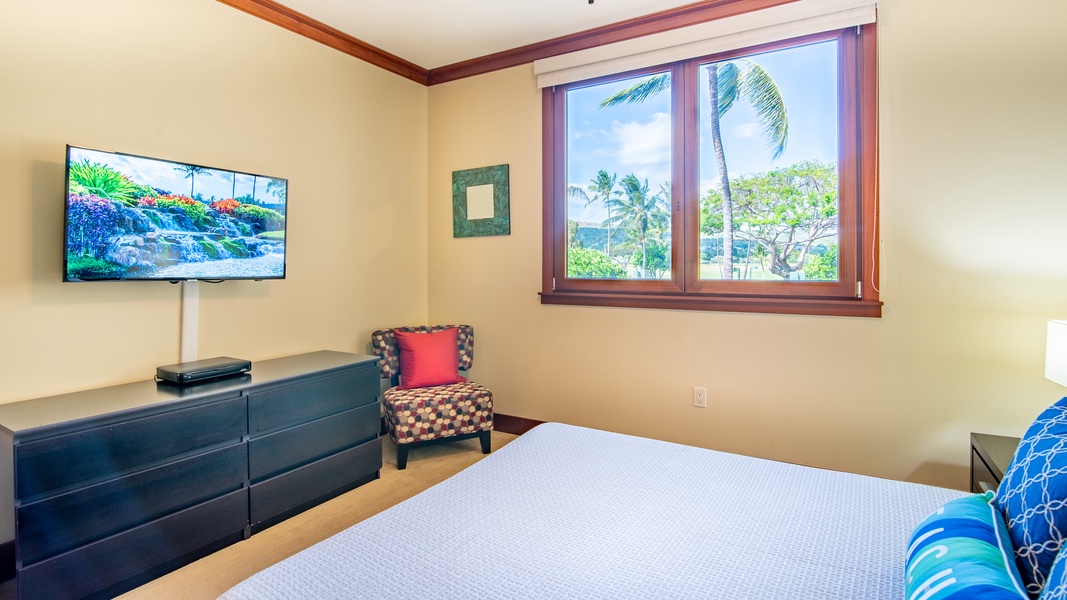 The second guest bedroom with a TV and ceiling fan and views.