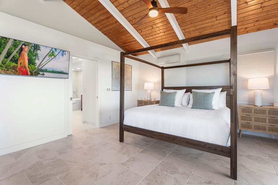 Primary suite with a plush king bed clothed in fine linens and an ensuite bathroom