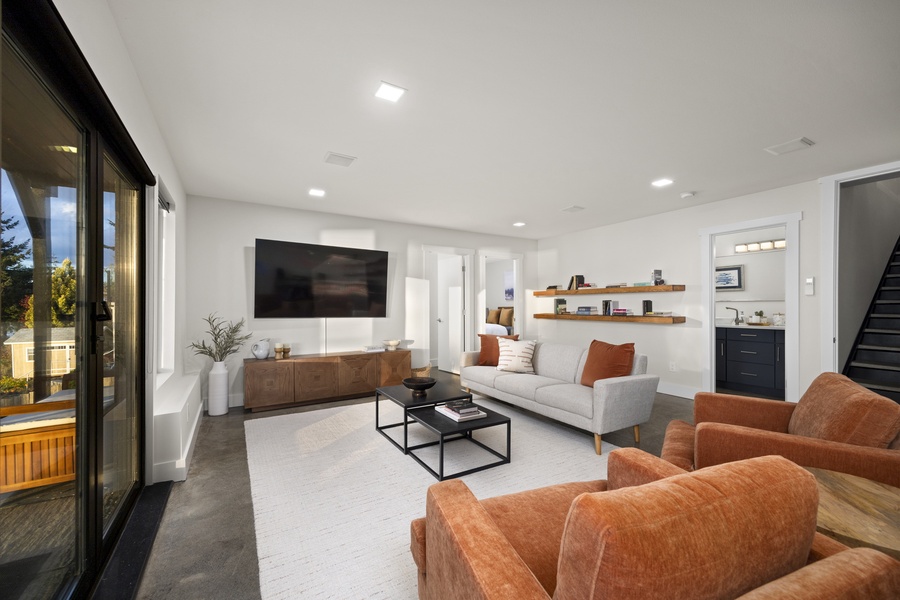 Spacious family room with warm accents and contemporary design — a versatile retreat for downtime and connection.