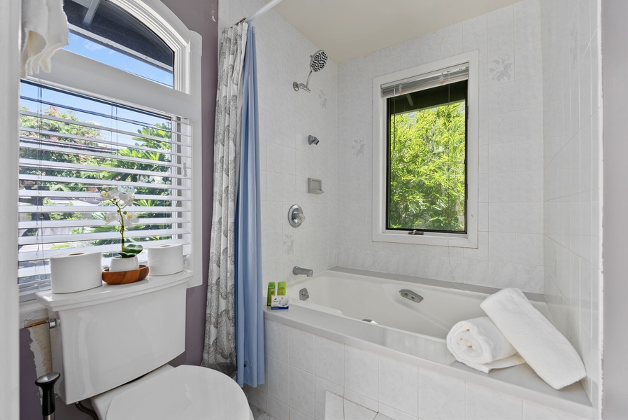 The bathroom has shower and tub combo.