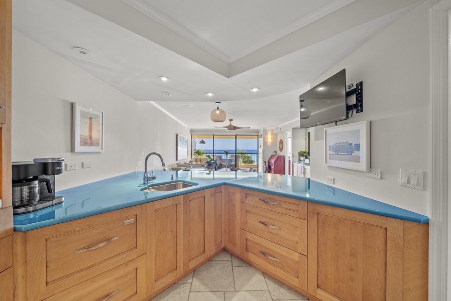 Prepare meals with a view in this fully equipped kitchen, featuring vibrant countertops and ocean vistas.