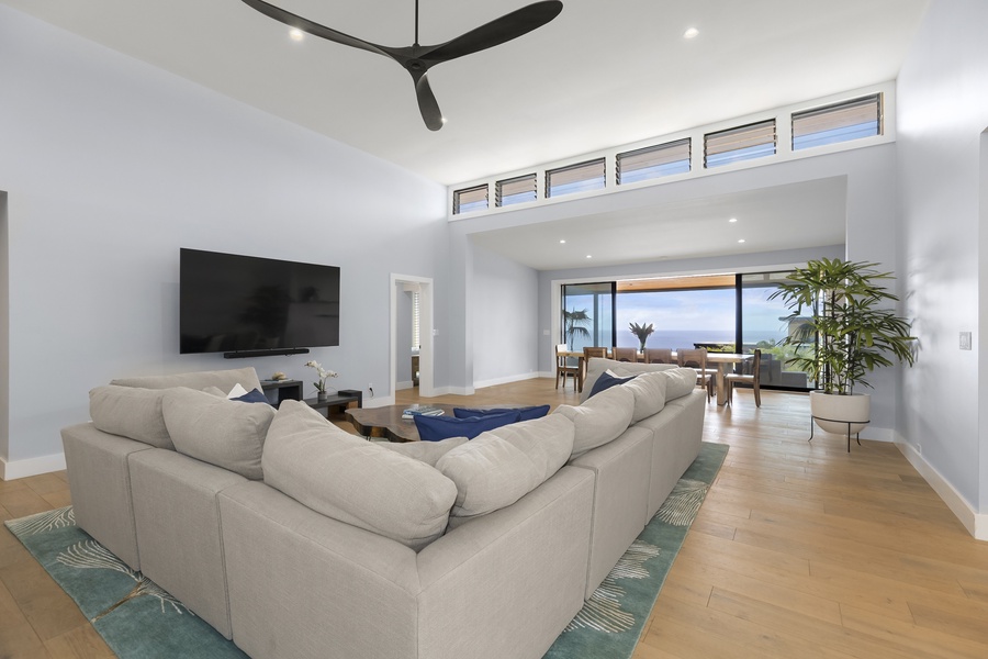 Seamless indoor-outdoor flow connects the spacious living area to the lanai, garden, and ocean views beyond.