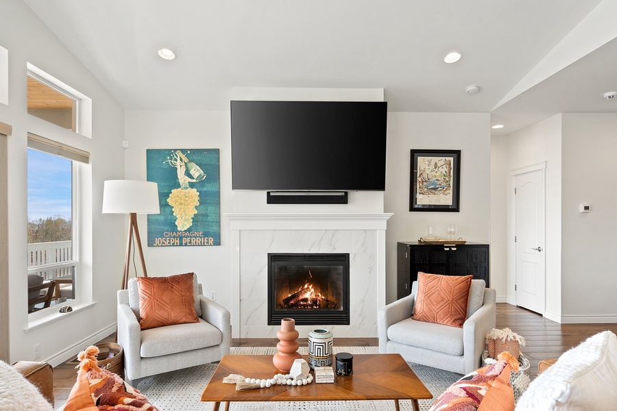 Engaging conversations and cozy moments unfold by the fireplace in the inviting living area