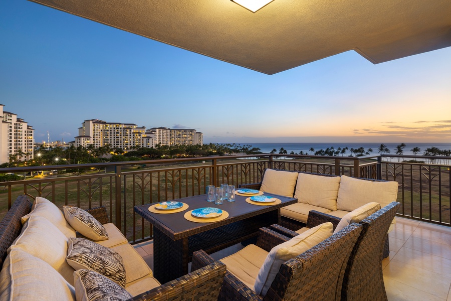 Balcony dining with twilight skies and an ocean backdrop.