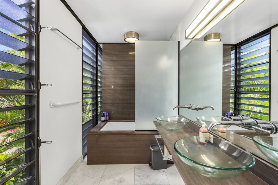 A spa-like bathroom with a soaking tub, sleek design, dual vessel sinks, and natural light.