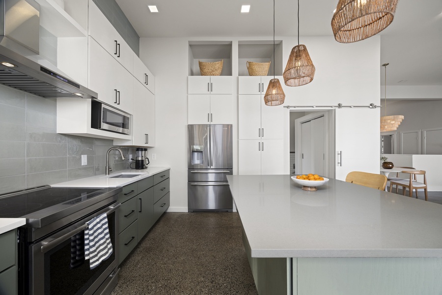Fully equipped kitchen with stainless-steel appliances and open shelving — both stylish and functional for any meal.