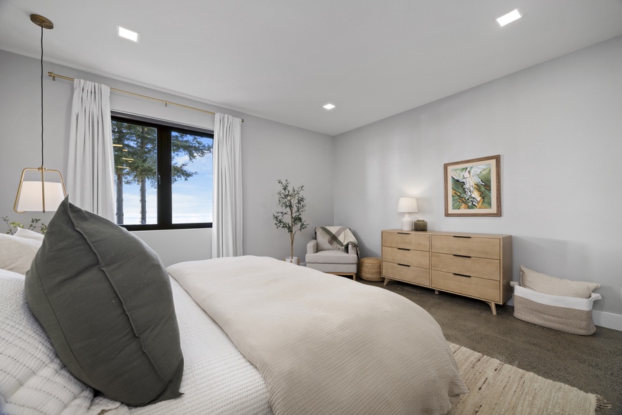 Bright and airy guest bedroom with cozy bedding, warm textures, and peaceful garden views.