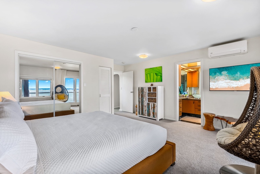 Comfortable guest suite with soft textures, warm woods, and garden views just outside.