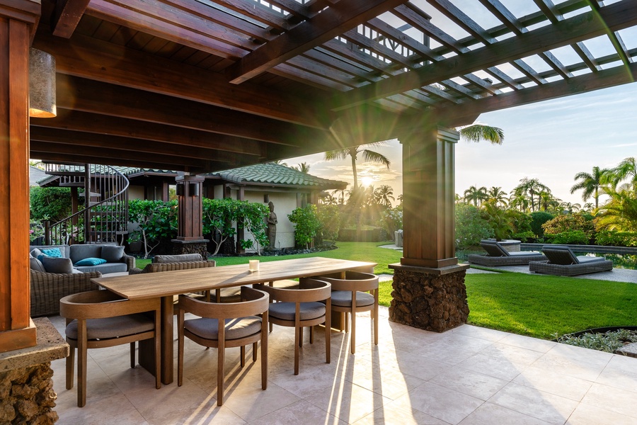 Elegant outdoor dining space with wood pergola and views of tropical gardens.