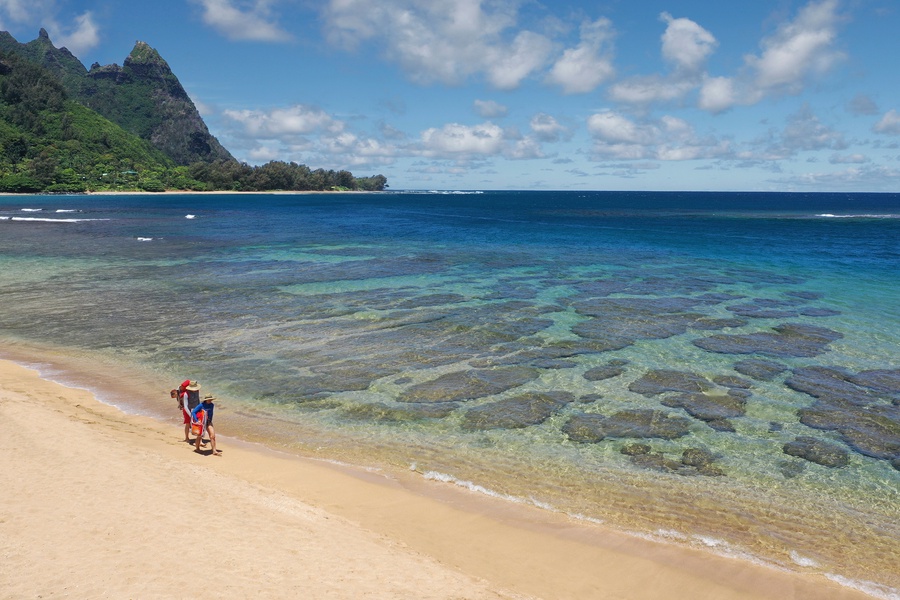 Peaceful shoreline at Tunnels Beach with clear waters, perfect for snorkeling or relaxing by the sand.