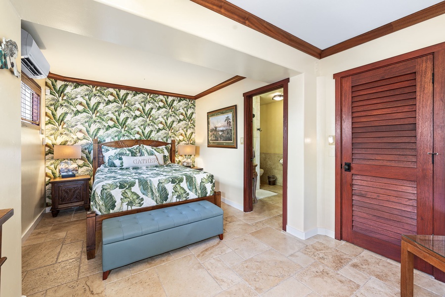 Another view of the island-style bedroom, featuring en-suite access and cool tile flooring.