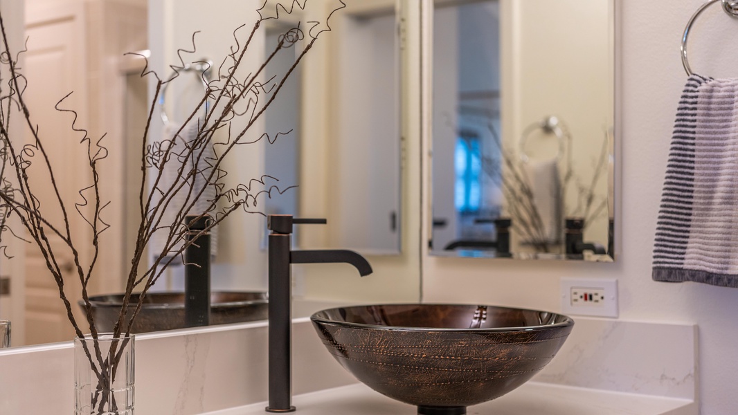 The primary guest bathroom with bold designs and contoured vanity sinks.