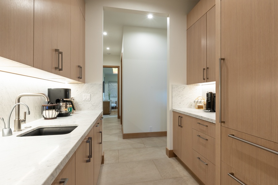 Your gourmet galley kitchen features sleek wood cabinetry, marble counters, and premium appliances for effortless meal prep.