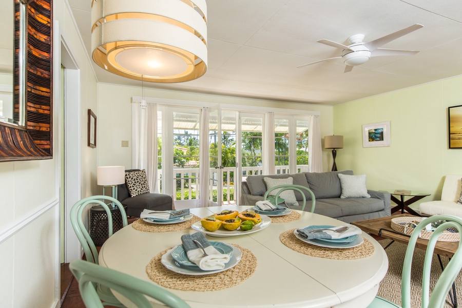 Gather around the dining table in Lanikai Cottage's main house, where natural light and cozy decor set the perfect ambiance.