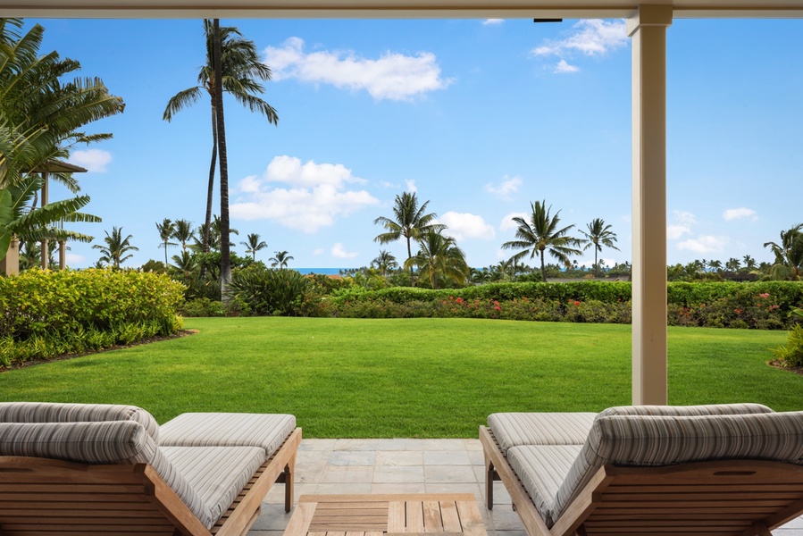 View of the expansive lawn from the lower lanai loungers.