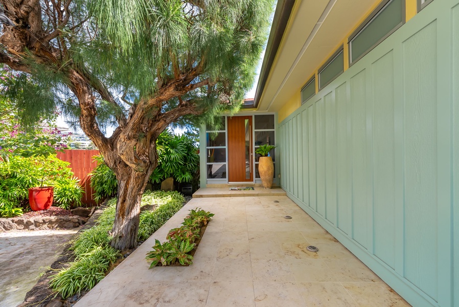 Charming front entry framed by island greenery and architectural lines.