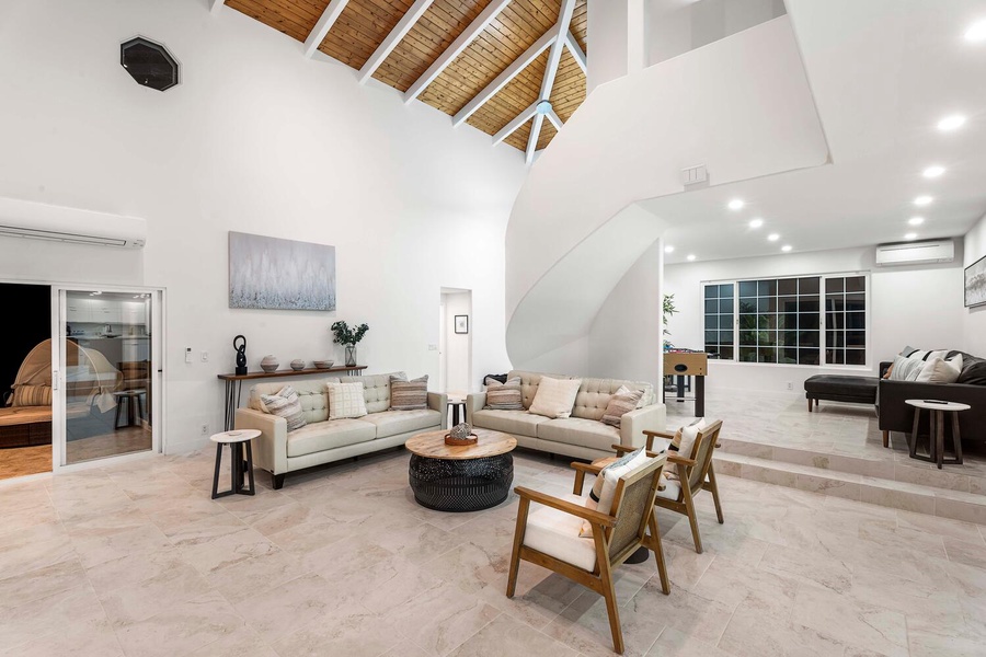 Flounder in the spaciousness of the living area, highlighted by soaring vaulted ceilings and sumptuous sofas.