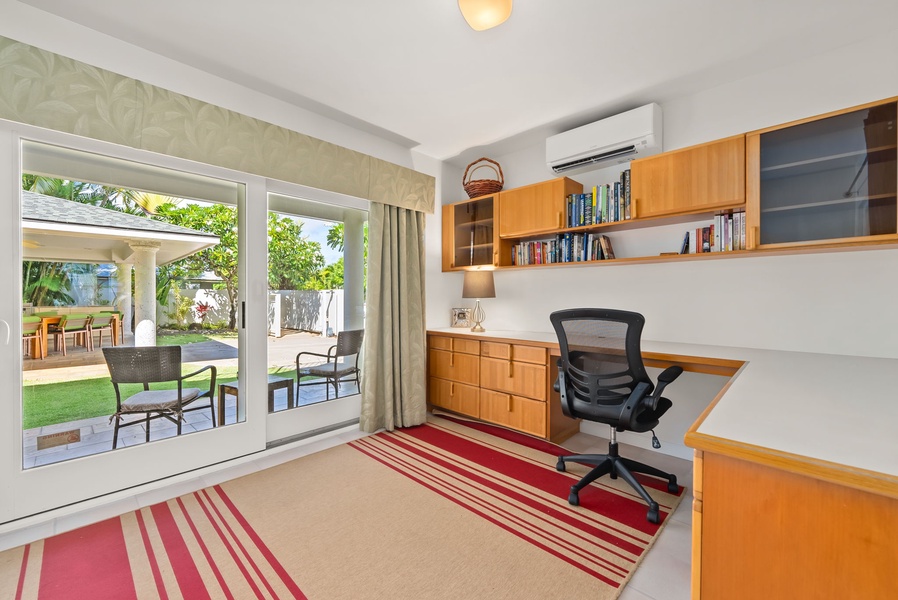 Home office with a desk, bookshelves, and direct access to the garden for a pleasant and productive space.