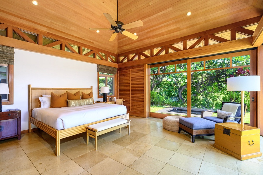 The primary suite boasts a sanctuary of tranquility, featuring lofted ceilings, a king bed and wall-to-wall sliders opening directly to the hot tub and pool.