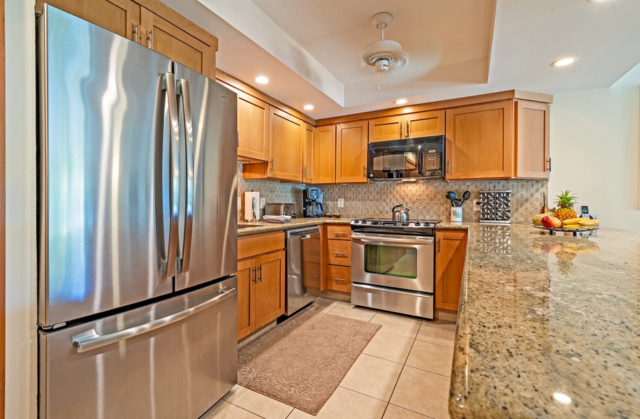 The fully equipped kitchen features stainless steel appliances, granite countertops, and ample cabinetry.