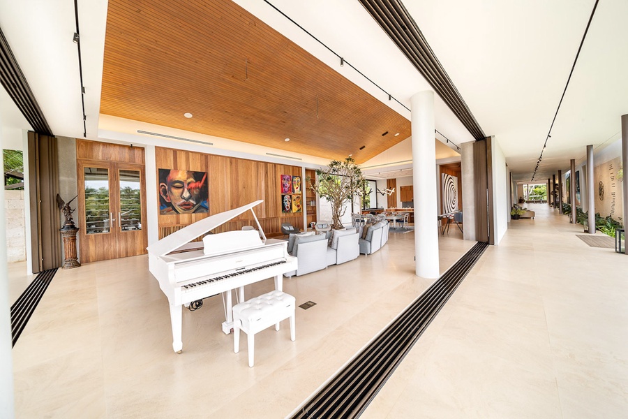 The sleek white grand piano and modern living space with artistic touches.