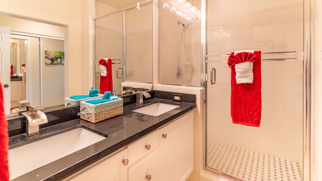 The primary guest bathroom featuring a double vanity and walk-in shower.