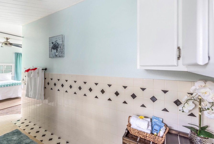 Sleek bathroom with decorative tile accents and a neatly arranged basket of essentials to make your stay comfortable.