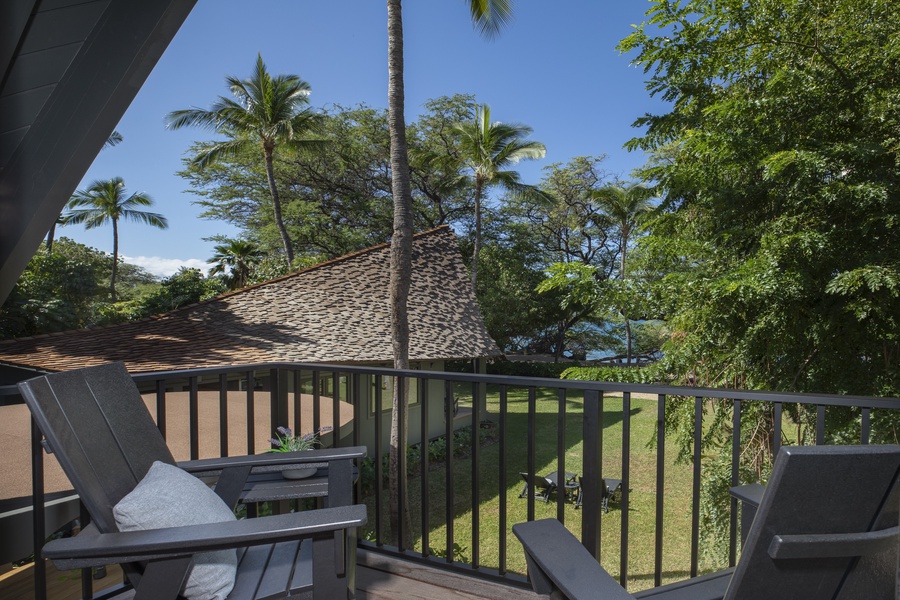 Private balcony with views of palm trees and the lush tropical landscape.