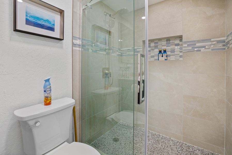 Stylish bathroom with elegant tilework and a sleek, glass-enclosed shower at Kaanapali Shores 213