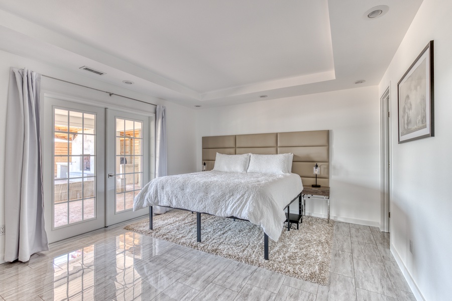 Primary bedroom is spacious and connected to patios through french doors