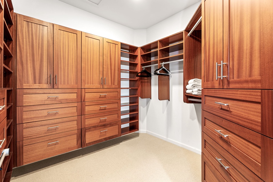 Spacious walk-in closet with custom wood cabinetry, providing plenty of storage for extended stays.